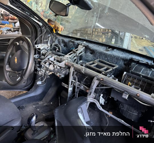 פנים רכב מפורק עם חוטי חשמל חשופים ולוח מחוונים חסר